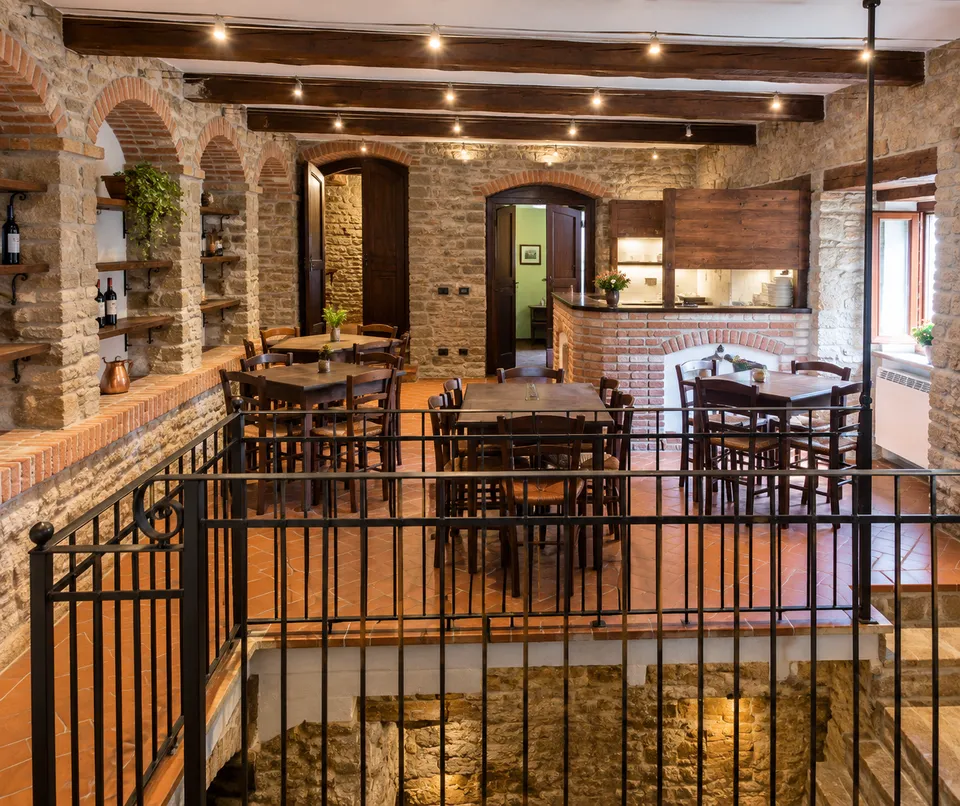 The dining room at Il Crutìn, with tables, stone walls and a brick counter